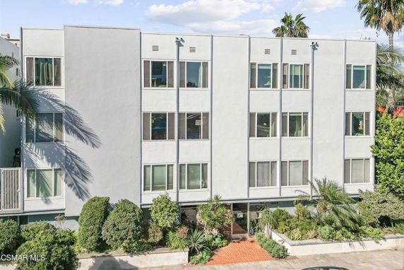 Front view of a multi-story residential building with multiple windows.