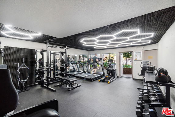 Indoor gym area with exercise equipment and overhead lighting