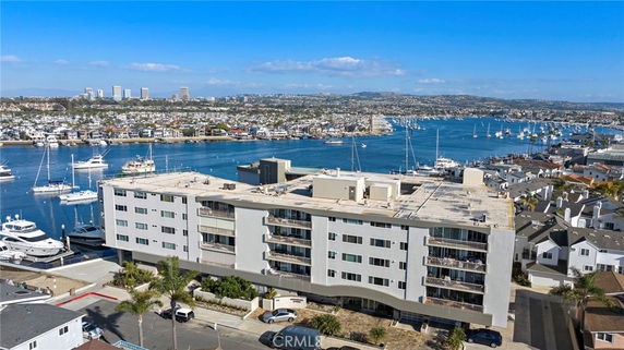 Front view of a multi-story waterfront building with balconies.