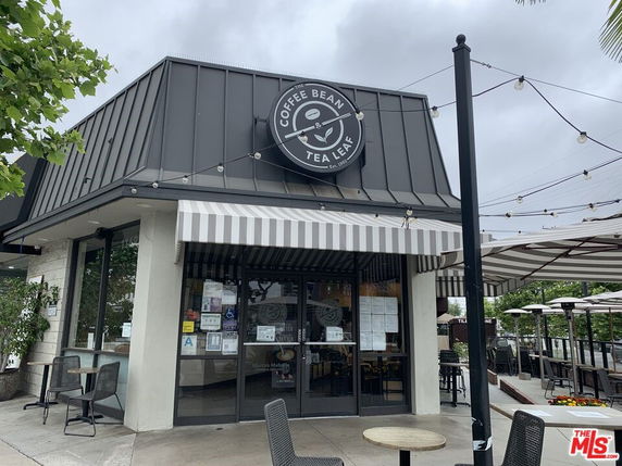 Front view of a coffee shop with an outdoor seating area.