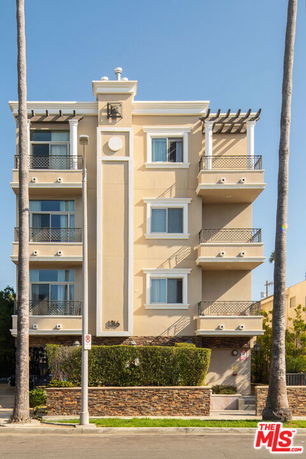 Front view of a multi-story apartment building with balconies.