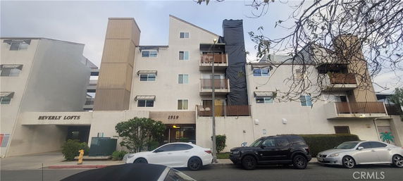 Front view of a multi-story building with balconies and various architectural features.