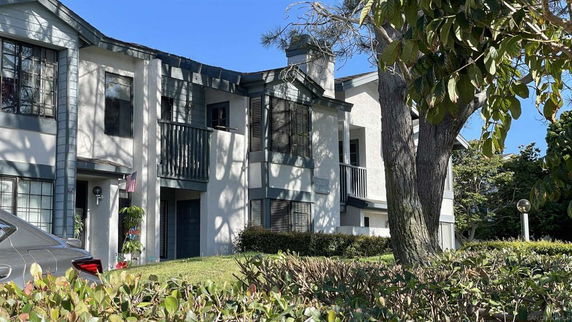 Front view of a multi-story building with multiple windows and balconies.