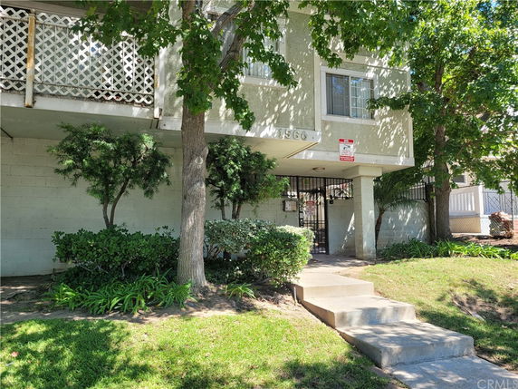 Front view of a two-story building with gated entrance and balconies.
