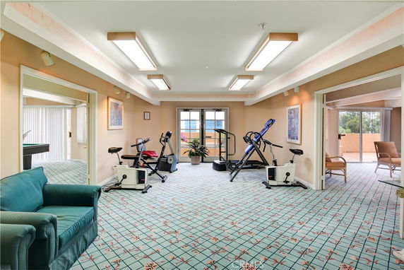 Indoor gym area with exercise equipment and bright lighting.