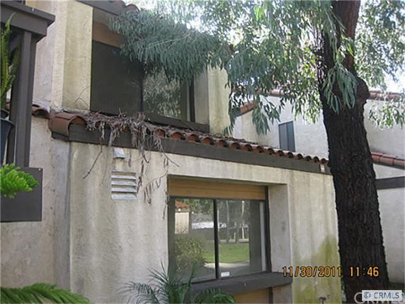 Front view of a multi-story house with large windows and a tiled roof.