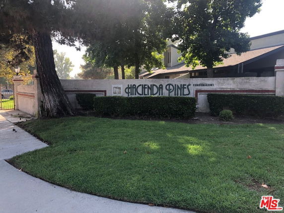 Front view of a condominium complex named Hacienda Pines.