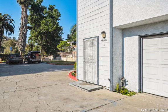 Outdoor parking area next to a building with garage door.
