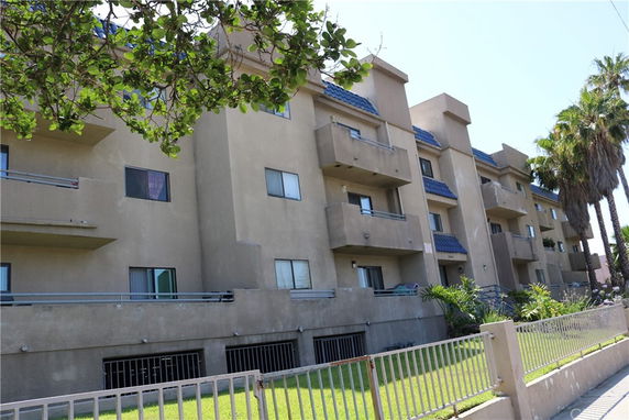 Front view of a multi-story apartment building with balconies.