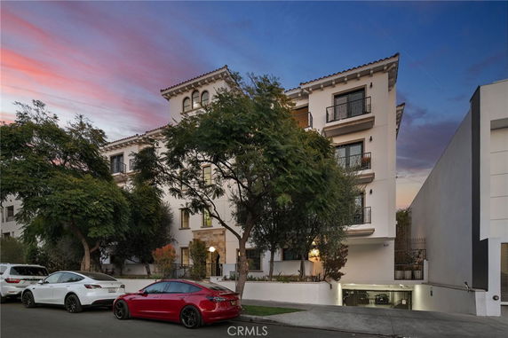 Front view of a multi-story building with multiple balconies and Spanish-style architecture.