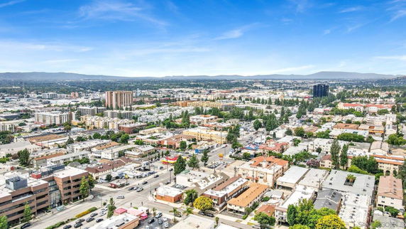 Aerial panoramic view of a cityscape with multiple buildings and streets.