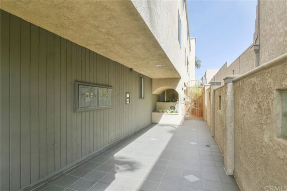 Side view of a building with exterior mailboxes and a walkway.