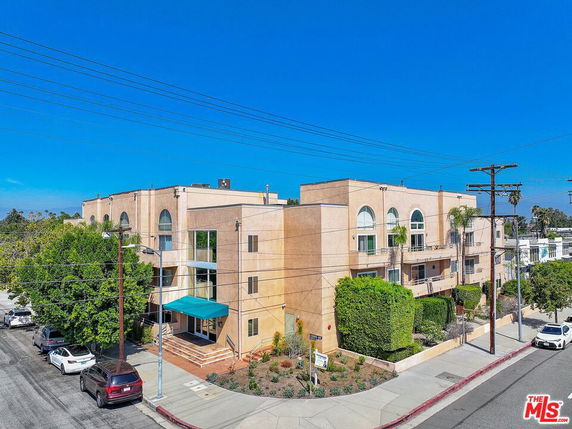 Front view of a multi-story residential building with large arched windows and balconies.