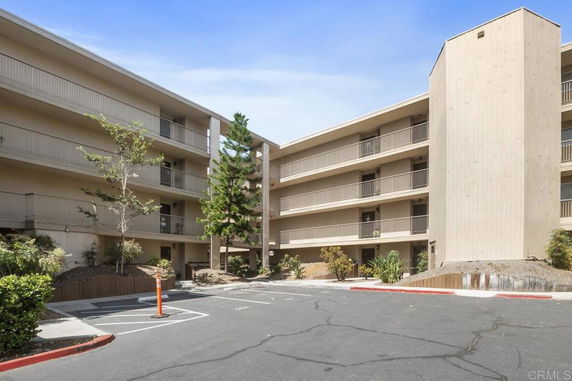 Front view of a multi-story apartment building with balconies.