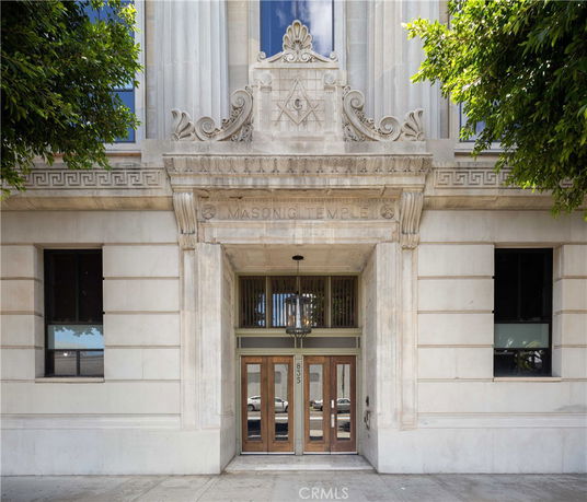 Front view of a Masonic Temple building with ornate stonework and large wooden doors.