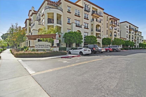 Front view of a multi-story apartment building with balconies.
