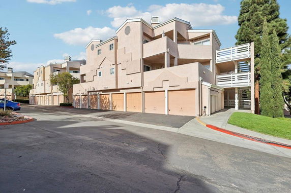 Front view of a multi-story residential building with garages.
