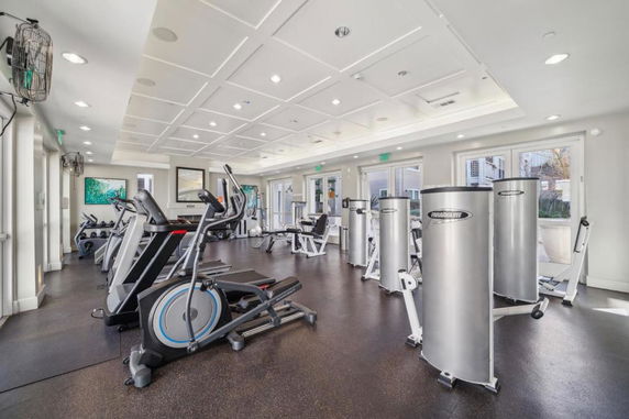Indoor gym area equipped with various exercise machines and weights.