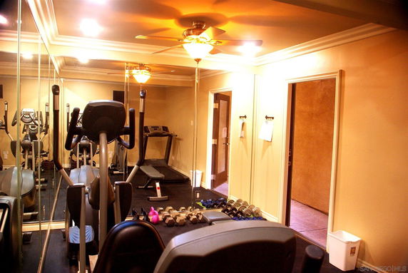 Indoor gym area with exercise equipment and mirrors.
