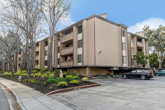 Front view of a multi-story apartment building with balconies.