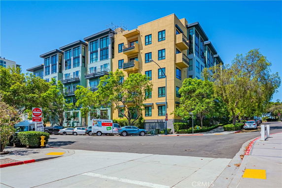 Front view of a multi-story residential building with balconies and large windows.