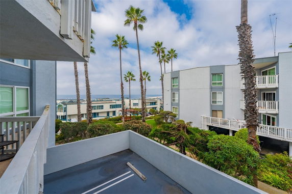 Panoramic view from a balcony overlooking buildings and palm trees.