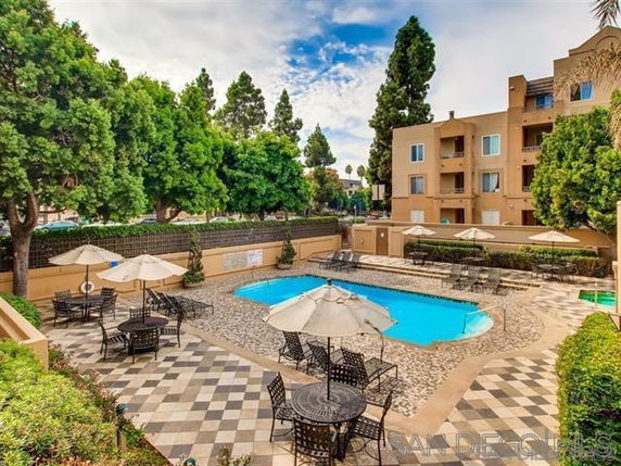 Outdoor view of a residential building with a swimming pool and patio area.