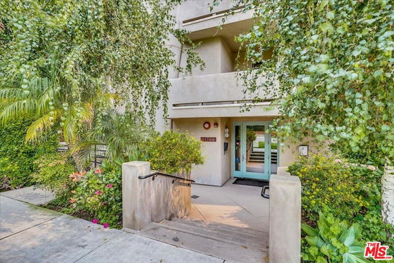 Front view of an apartment building with a landscaped entrance.