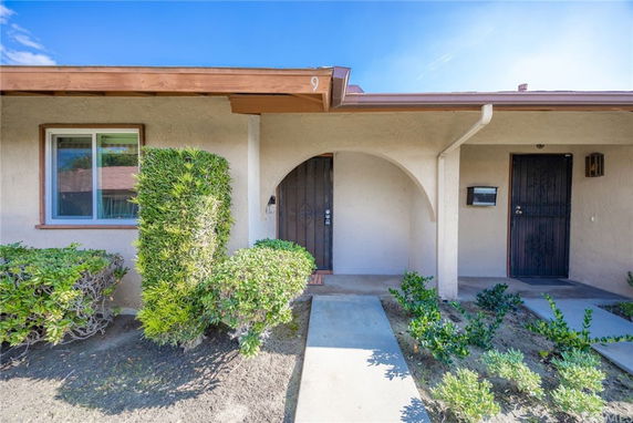 Front view of a house with an archway entrance and a single window.
