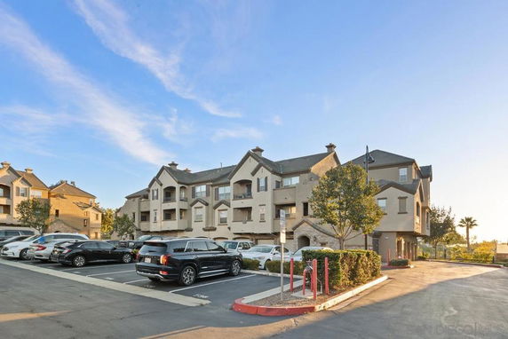 Front view of a multi-story residential building with a parking area.