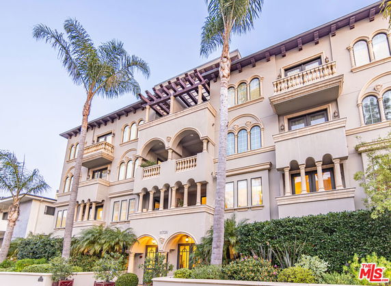 Front view of a multi-story building with balconies and decorative arches.