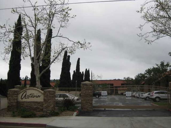 Front view of a building complex with a gated entrance and parking area.