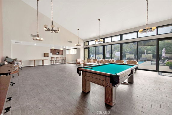 Recreational room with a pool table and large windows.