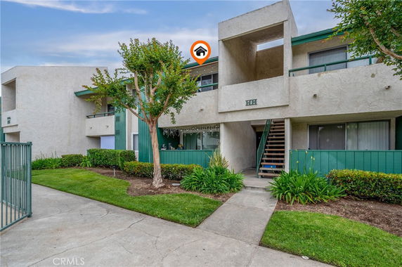 Front view of a two-story apartment building with external staircase.