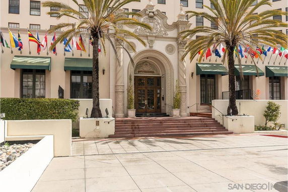 Front view of a building with decorative entrance and multiple flags displayed.