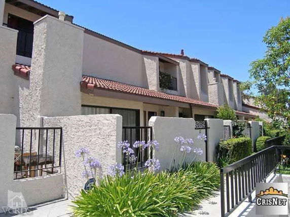 Front view of a multi-story townhouse with a tiled roof and balconies.