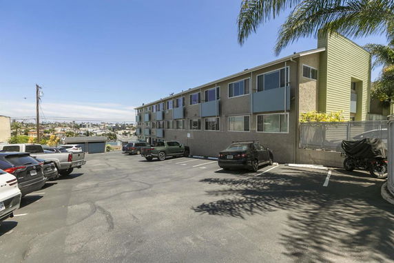 Outdoor parking area in front of a multi-story building.