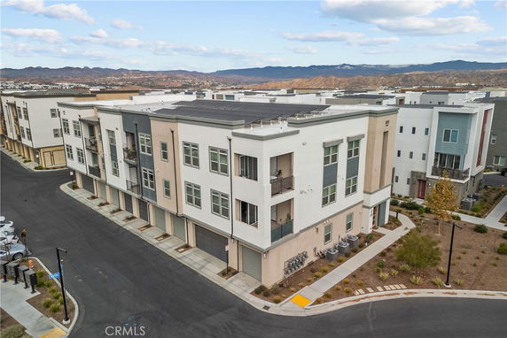 Front view of a multi-story residential building with balconies and a flat roof.