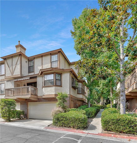 Front view of a two-story house with a balcony and double garage.