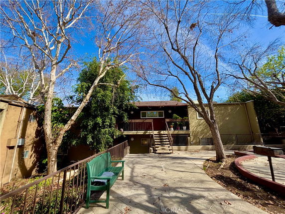 Front view of a two-story building with an exterior staircase leading to the main entrance.