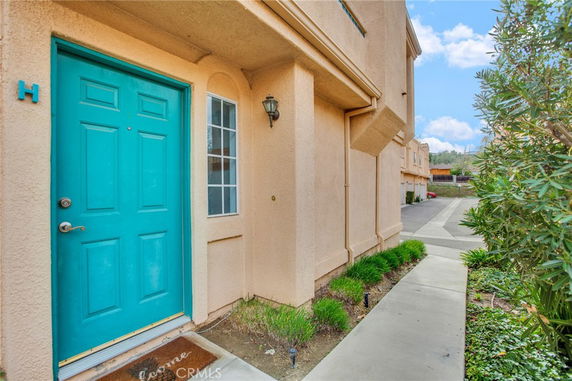Front view of a house with a blue door and beige exterior walls.