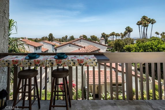 Elevated view of residential rooftops with palm trees in the distance.