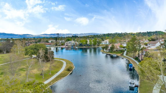 Wide view of a lake surrounded by houses and trees.
