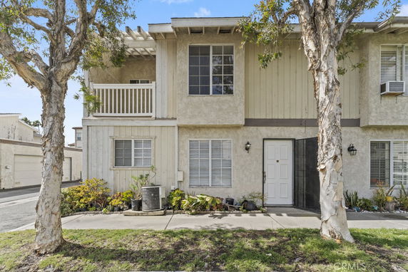 Front view of a two-story house with a small balcony and white exterior.