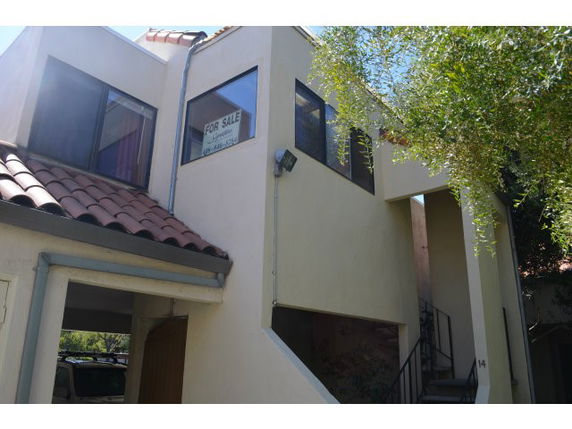 Front view of a two-story house with large windows and a tiled roof.