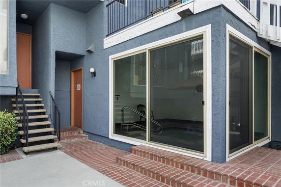 Exterior view of a building with blue stucco walls and large glass sliding doors.