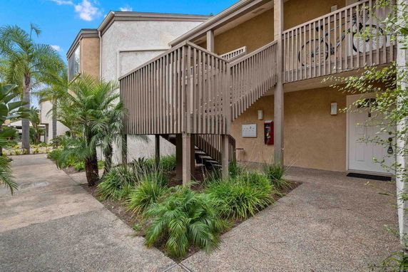 Front view of a house with an exterior staircase leading to an upper floor.