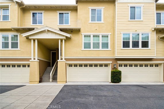 Front view of a two-story residential building with multiple garage doors.