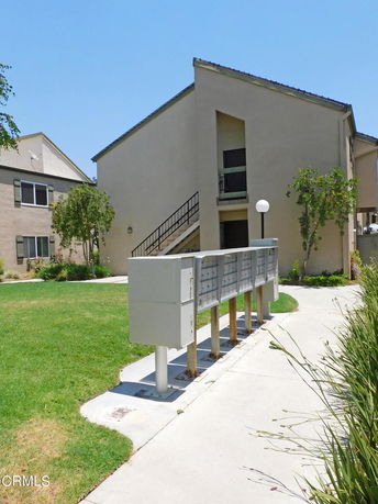 Front view of a multi-story building with sloped roofs and an outdoor staircase.