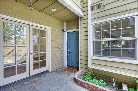 Front view of a house entryway with a blue door and glass French doors.